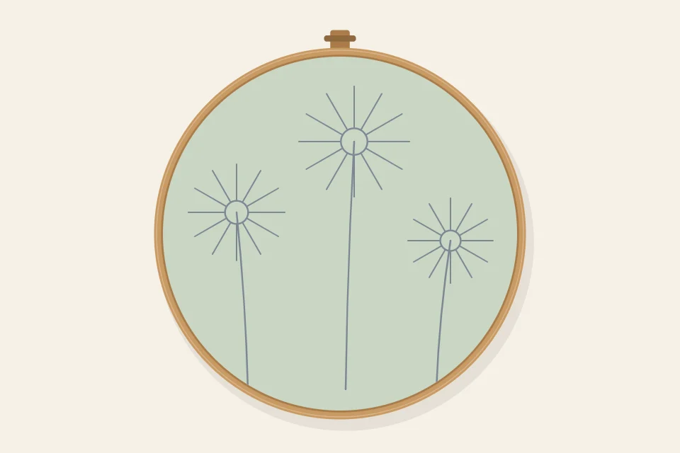 The drawn daisy design before stitching: three small center circles with radiating petal guide lines and three curved stem lines