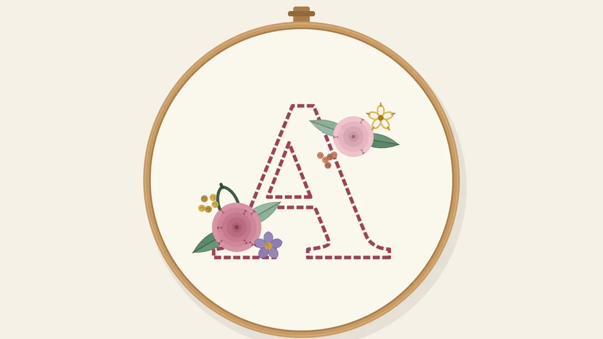 A large letter outlined in stitching with small flowers and leaves clustered on it, inside an embroidery hoop