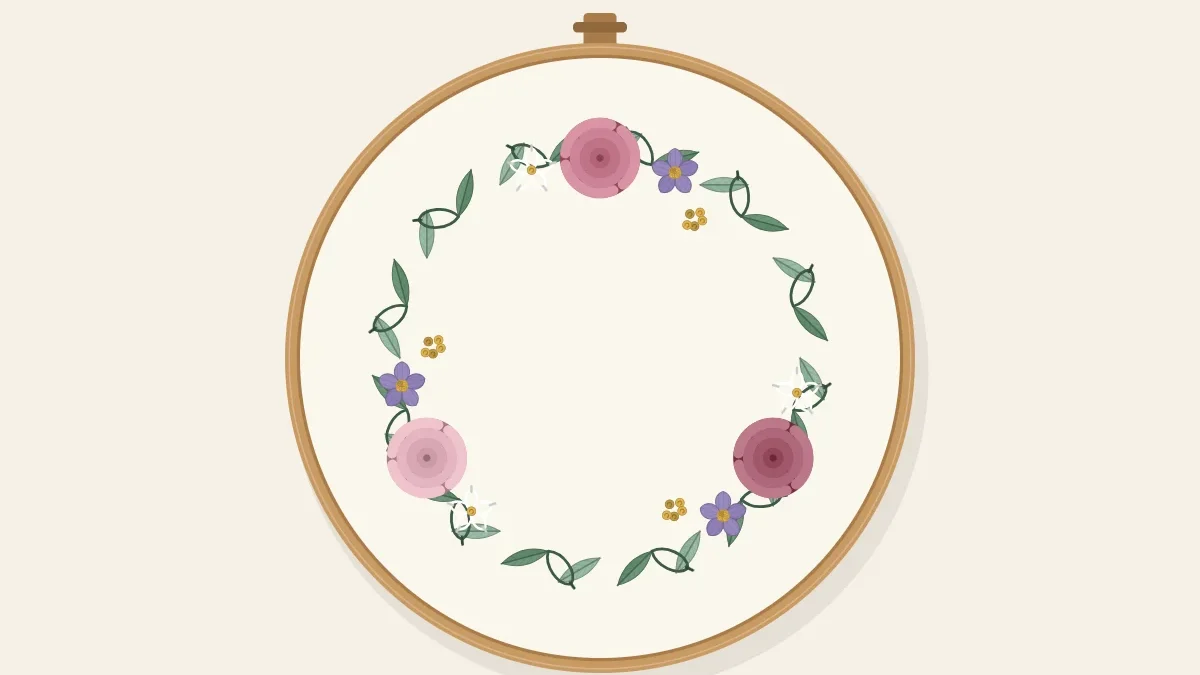 A floral wreath of small flowers and leaves stitched in a circle inside an embroidery hoop